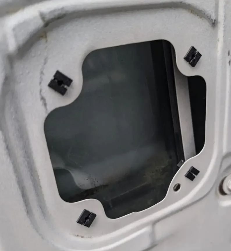 Speaker screw grommets pressed into the square holes of a Honda Acty door speaker opening
